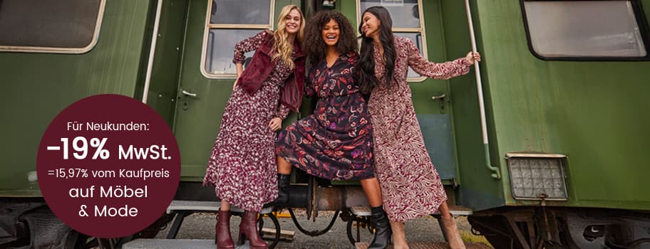 Für Neukunden: -19% MwSt. = 15,97% vom Kaufpreis auf Möbel & Mode – Drei Frauen in gemusterten Kleidern posieren vor einem Zug.