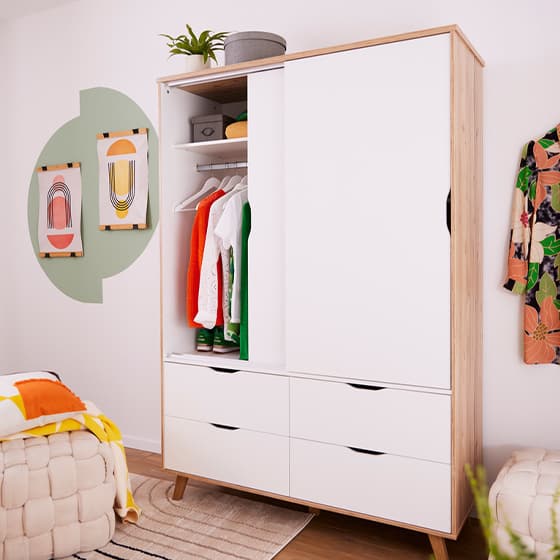 Nahaufnahme eines offenen Kleiderschranks mit farbenfroher Kleidung und dekorativen Gegenständen.