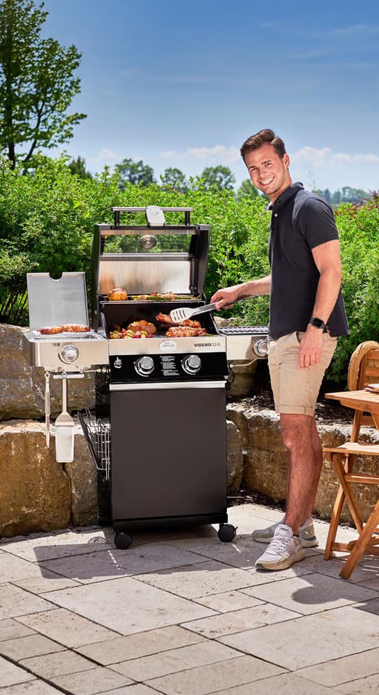 Mann vor einem Griller