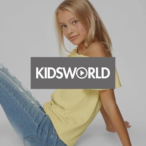 KIDSWORLD – Mädchen in gelbem Oberteil und blauer Jeans sitzt auf Boden, Gesicht unscharf