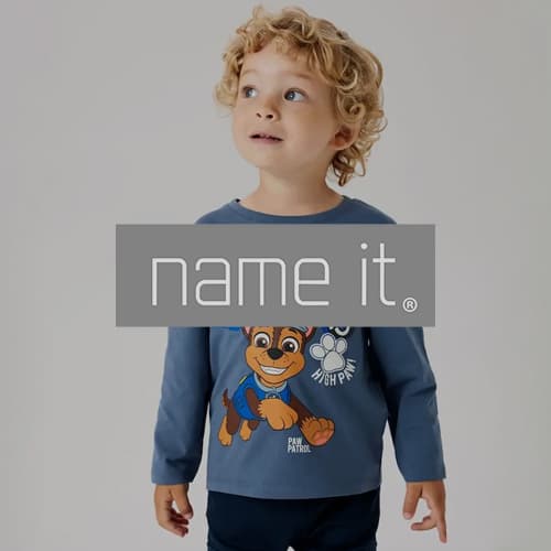 name it – Kind trägt blaues Paw Patrol Langarmshirt mit Hund und Pfotenabdruck darauf