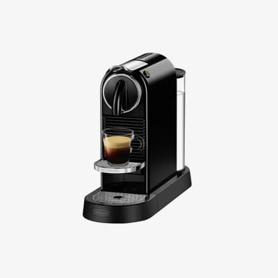 Schwarze Espressomaschine mit einem Glas Espresso auf der Tropfschale