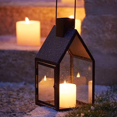 Laterne und Kerzen auf Steintreppe, leuchtend im Dunkeln