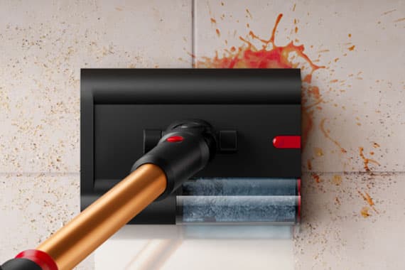 Wischmopp reinigt rote Flüssigkeitsspritzer auf Fliesenboden