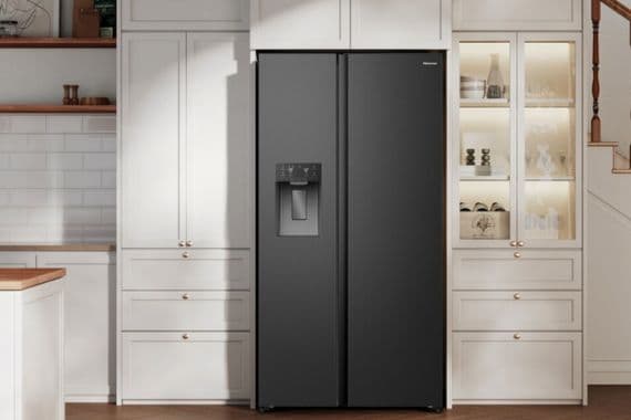 Kaffeemaschine auf Küchenarbeitsplatte neben Keksglas und blauem Kaffeebecher.